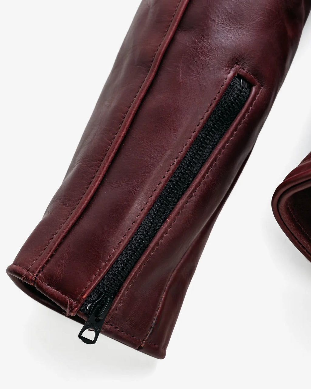 Close-up of a leather with a black zipper on a white background