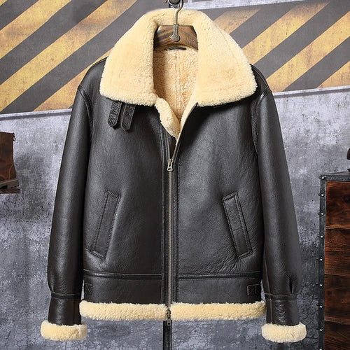 Black leather jacket with beige fur lining on a hanger against a rustic background