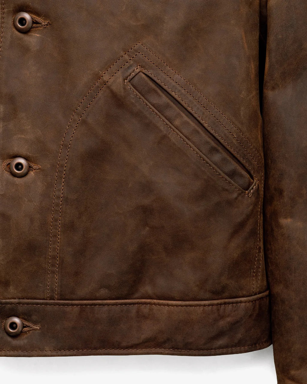 Close-up of a brown leather jacket with a pocket detail on a white background