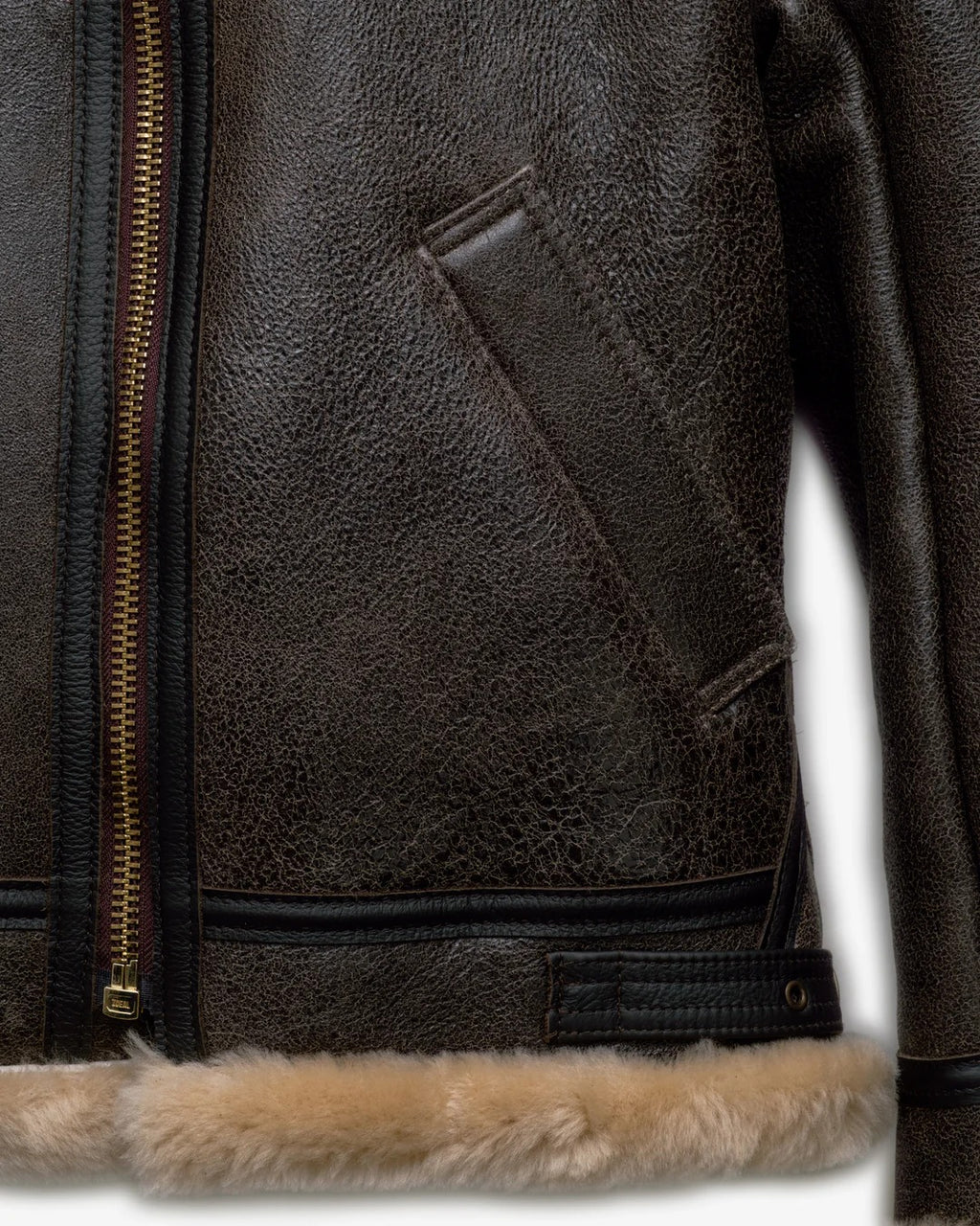 Close-up of a brown leather jacket with fur trim on a white background