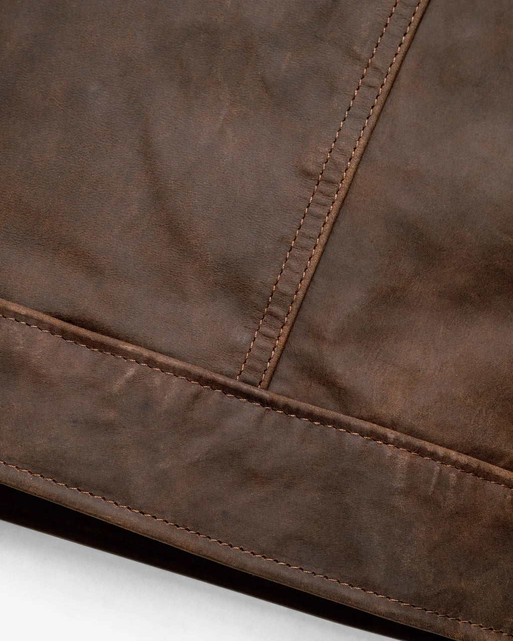 Close-up of a brown leather surface with stitching detail