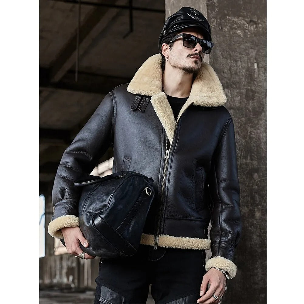 Man wearing a black leather jacket with shearling collar holding a helmet in an urban setting.
