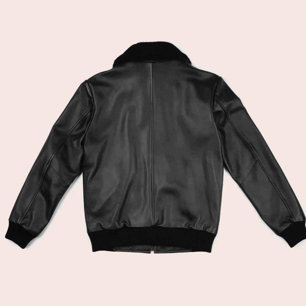 Black leather bomber jacket on a beige background