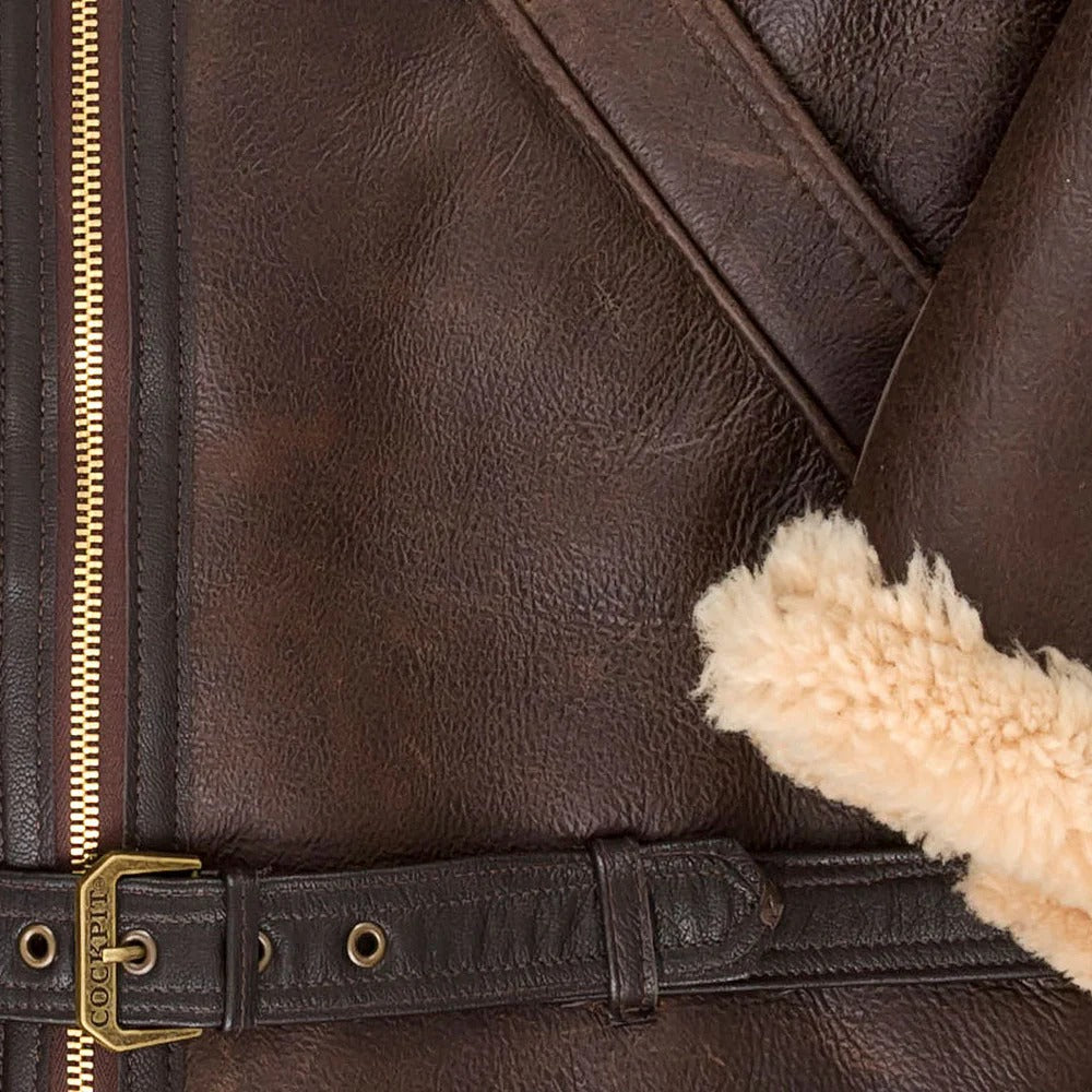 Close-up of a brown leather jacket with fur lining and gold zipper and buckle.