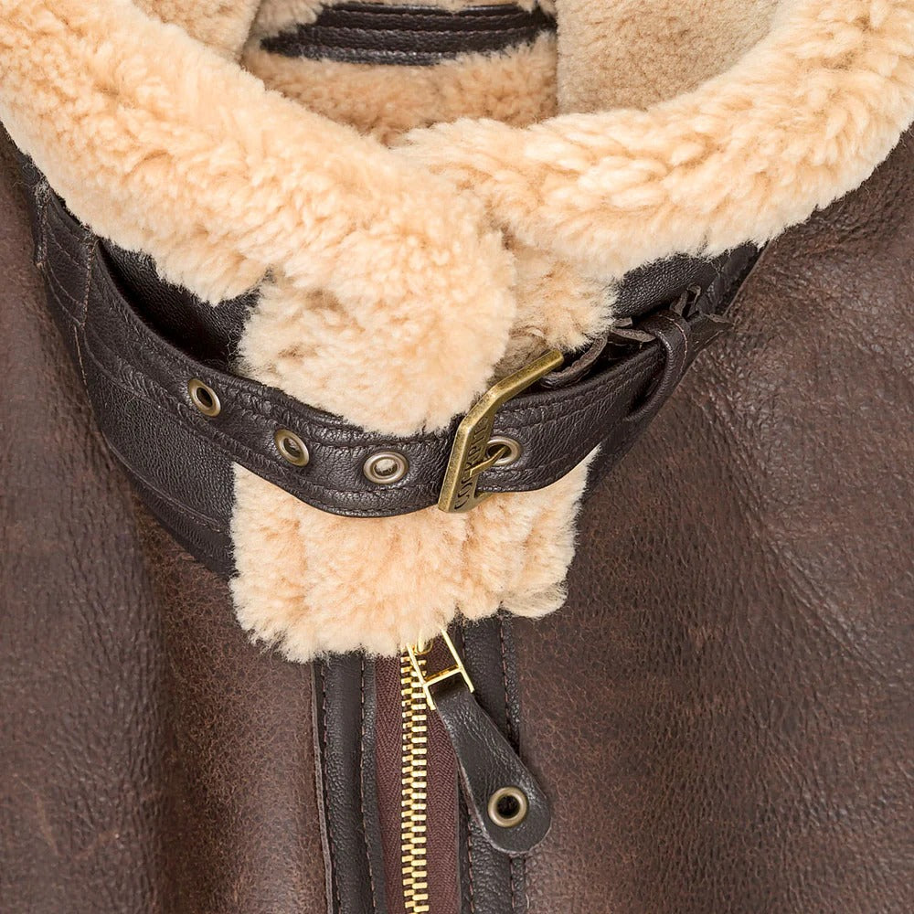 Close-up of a brown leather jacket with a fur-lined hood and gold zipper.