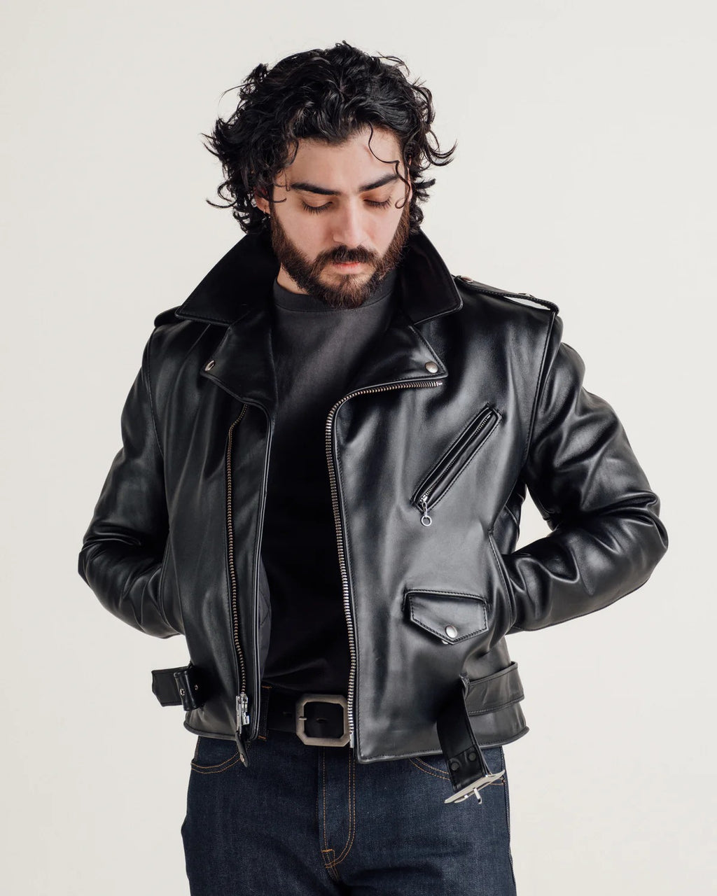 Man wearing a black leather jacket on a plain background