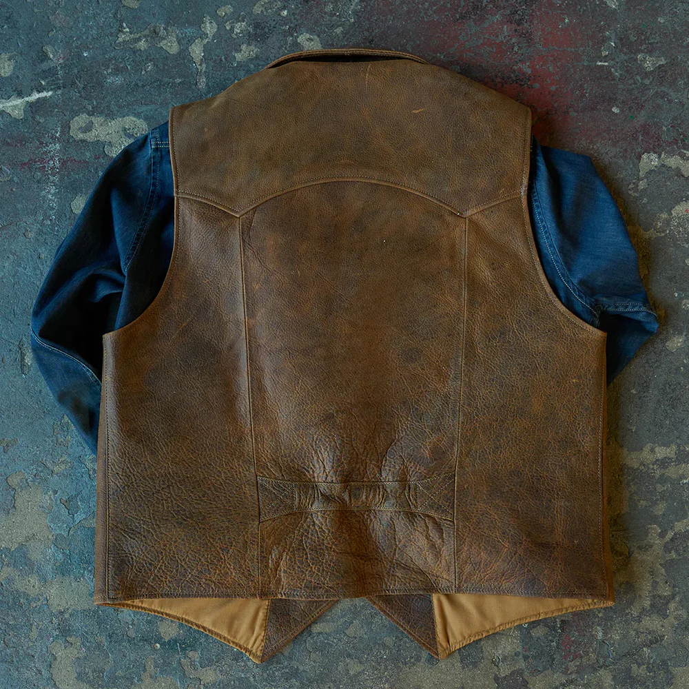 Brown leather vest on a textured blue surface