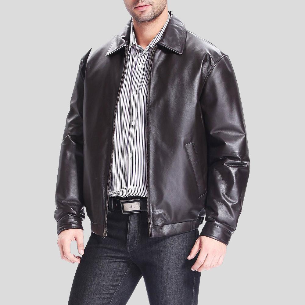 Man wearing a black leather jacket over a striped shirt on a gray background