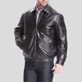 Man wearing a black leather jacket on a gray background
