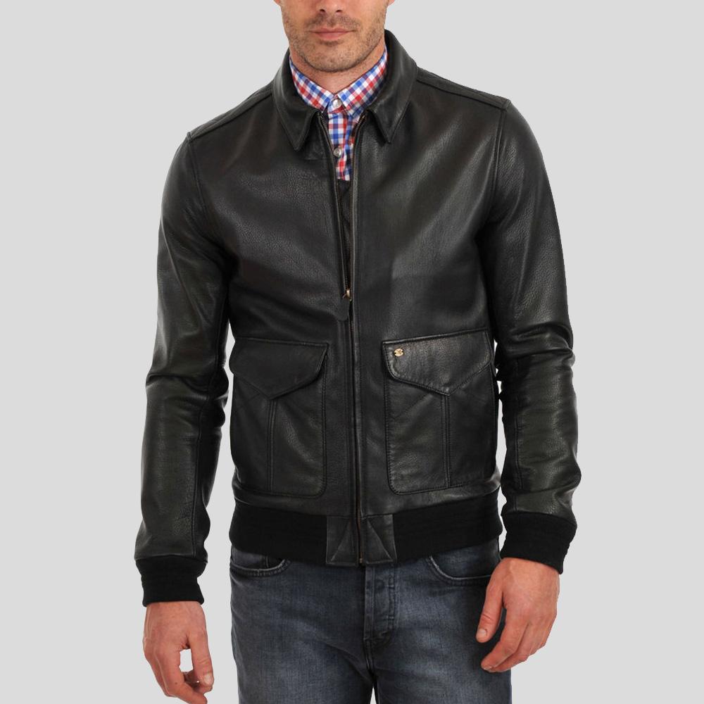 Man wearing a black leather jacket over a checkered shirt on a gray background