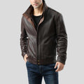 Man wearing a brown leather jacket on a gray background