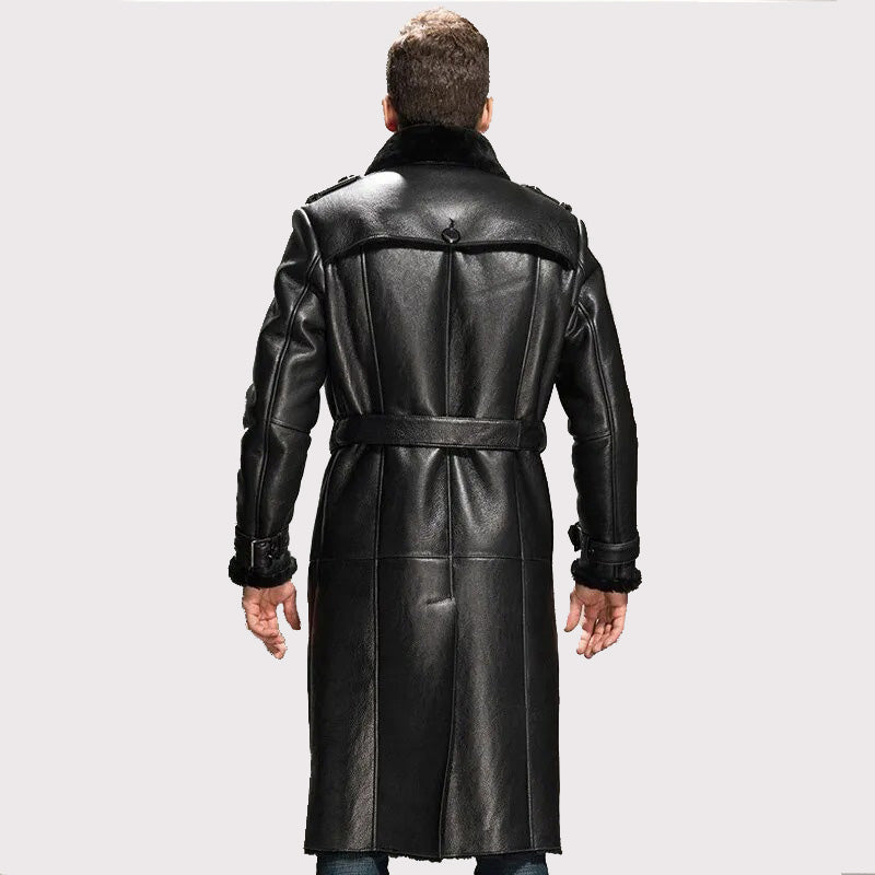 Man wearing a long black leather coat on a light gray background