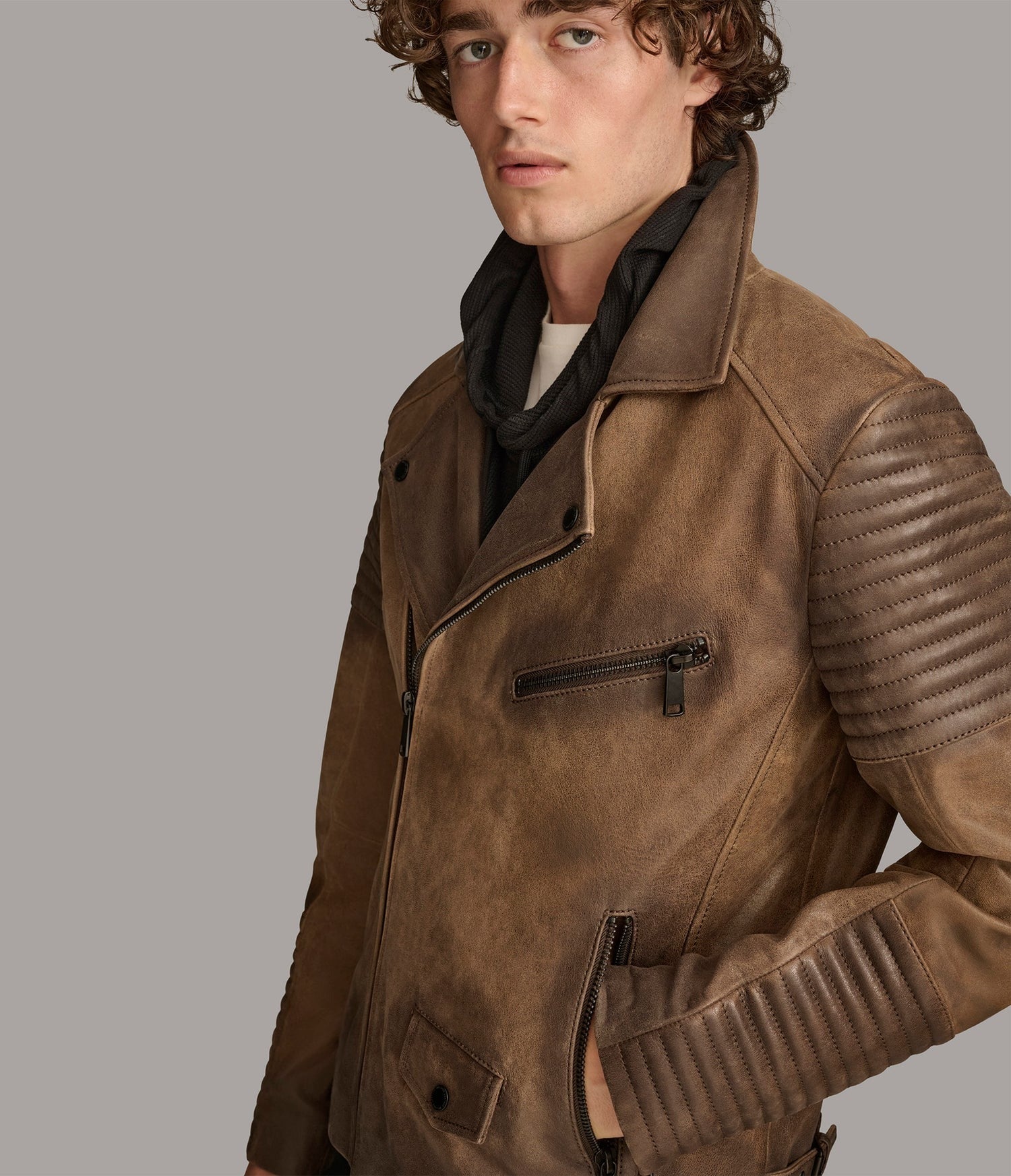 Man wearing a brown leather jacket on a gray background