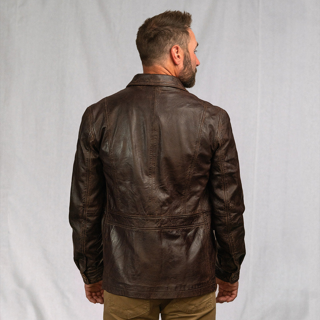 Man wearing a brown leather jacket against a plain background