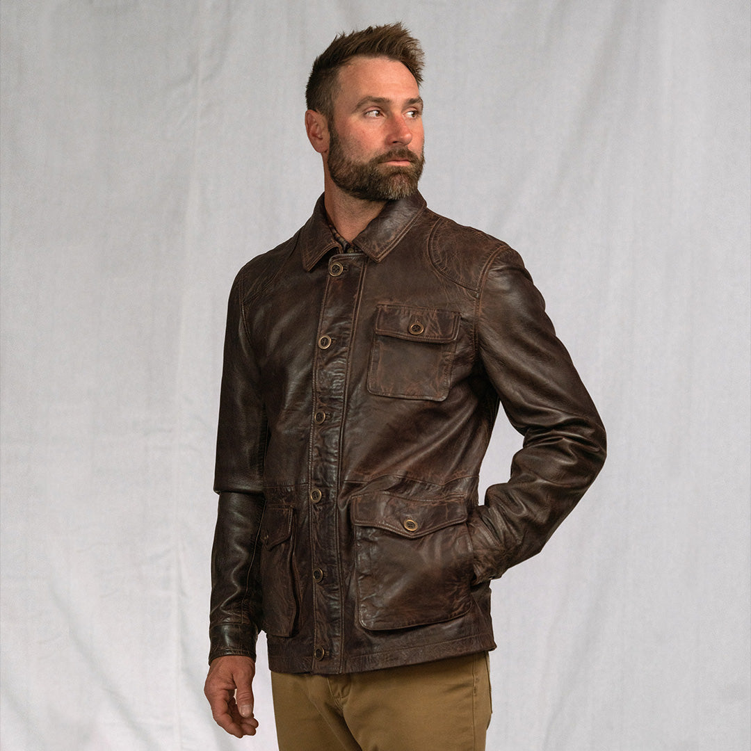 Man wearing a brown leather jacket against a plain background