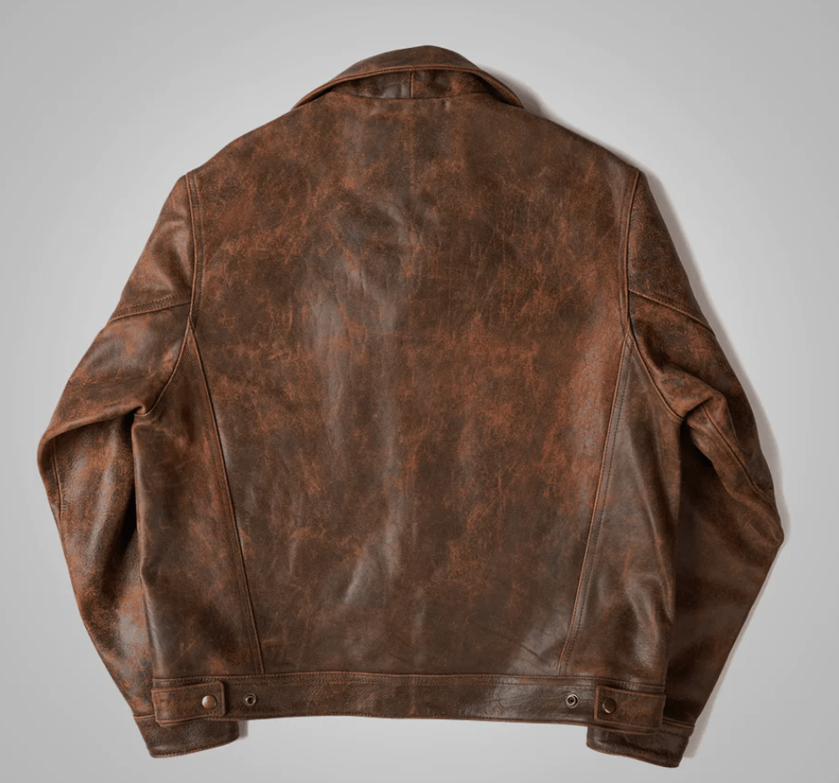 A brown distressed leather jacket shown from the back, laid flat against a neutral light gray background.