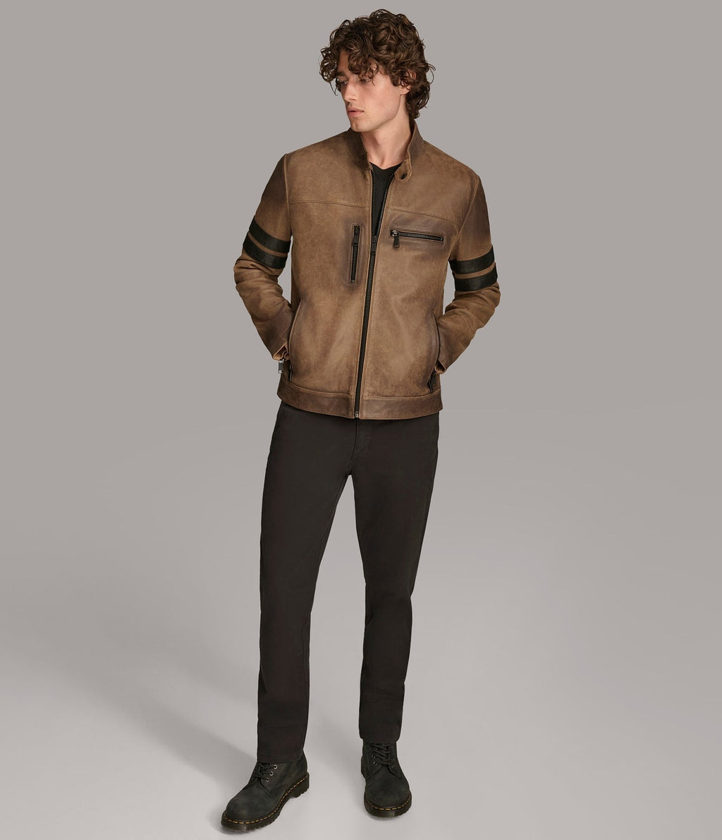 Man wearing a brown leather jacket with black accents on a gray background