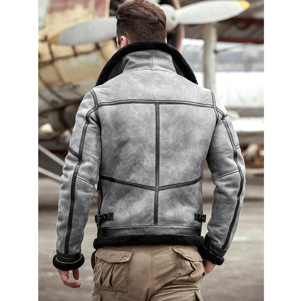 Person wearing a gray leather jacket with a vintage airplane in the background