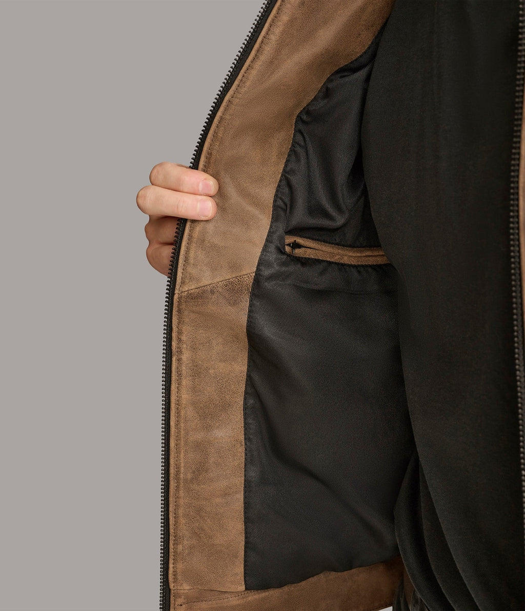 Close-up of a brown leather jacket with a zipper on a gray background