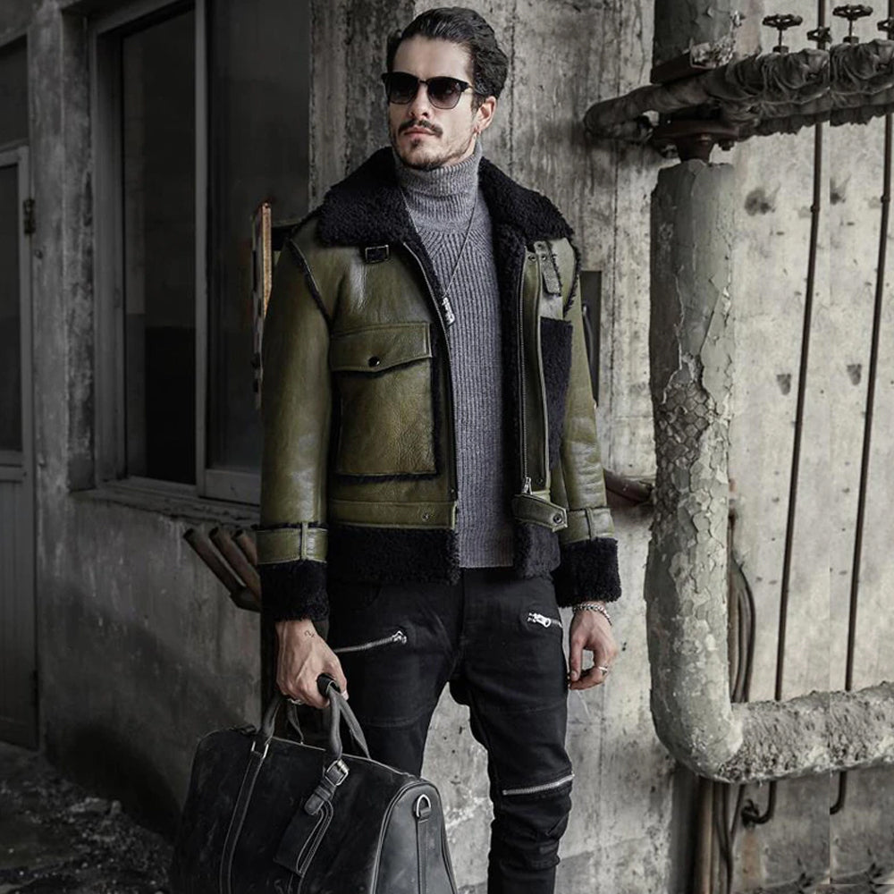 Man wearing a green leather jacket with fur collar, holding a bag, standing in front of an old building.