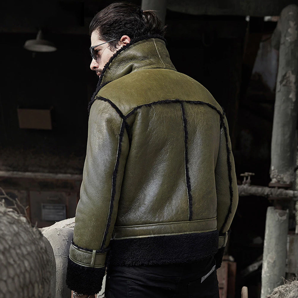 Person wearing a green leather jacket with black lining in an industrial setting