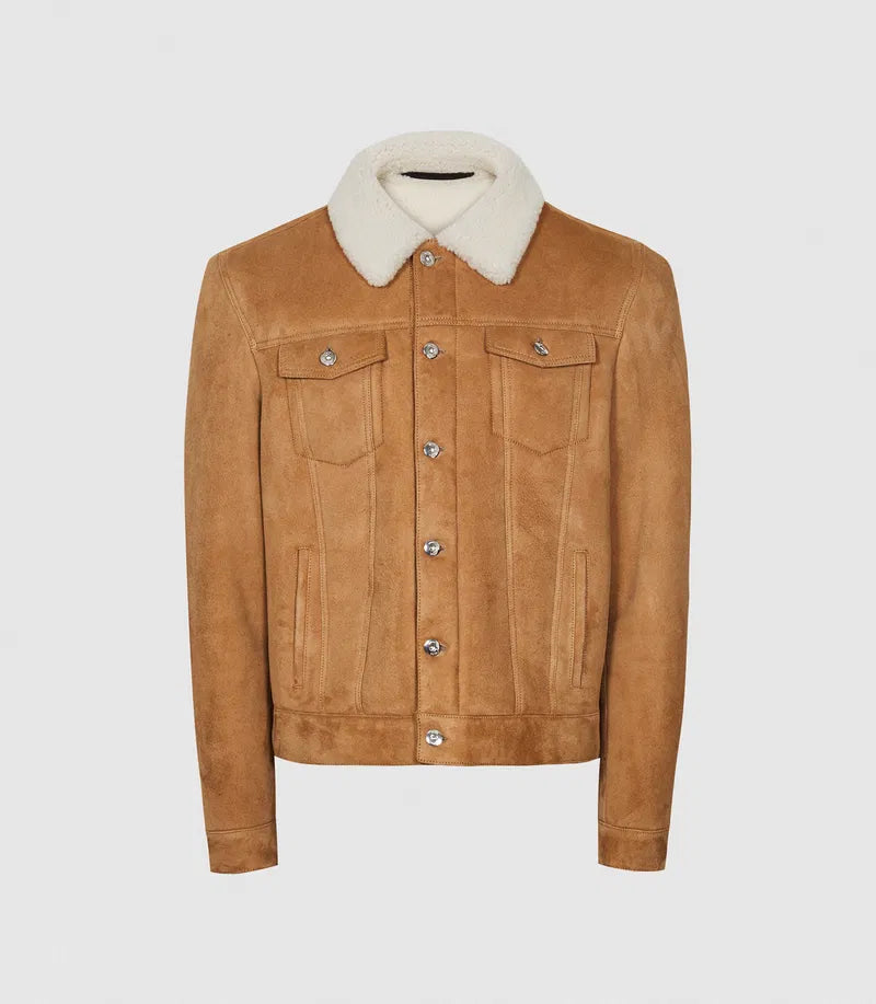 A tan suede trucker jacket with a contrasting cream-colored shearling-style collar, featuring silver snap buttons and flap chest pockets, displayed on a neutral light gray background.