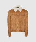 A tan suede trucker jacket with a contrasting cream-colored shearling-style collar, featuring silver snap buttons and flap chest pockets, displayed on a neutral light gray background.