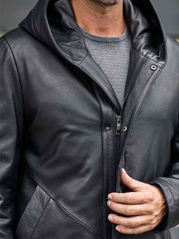 Close-up of a person wearing a black leather jacket with a hood.
