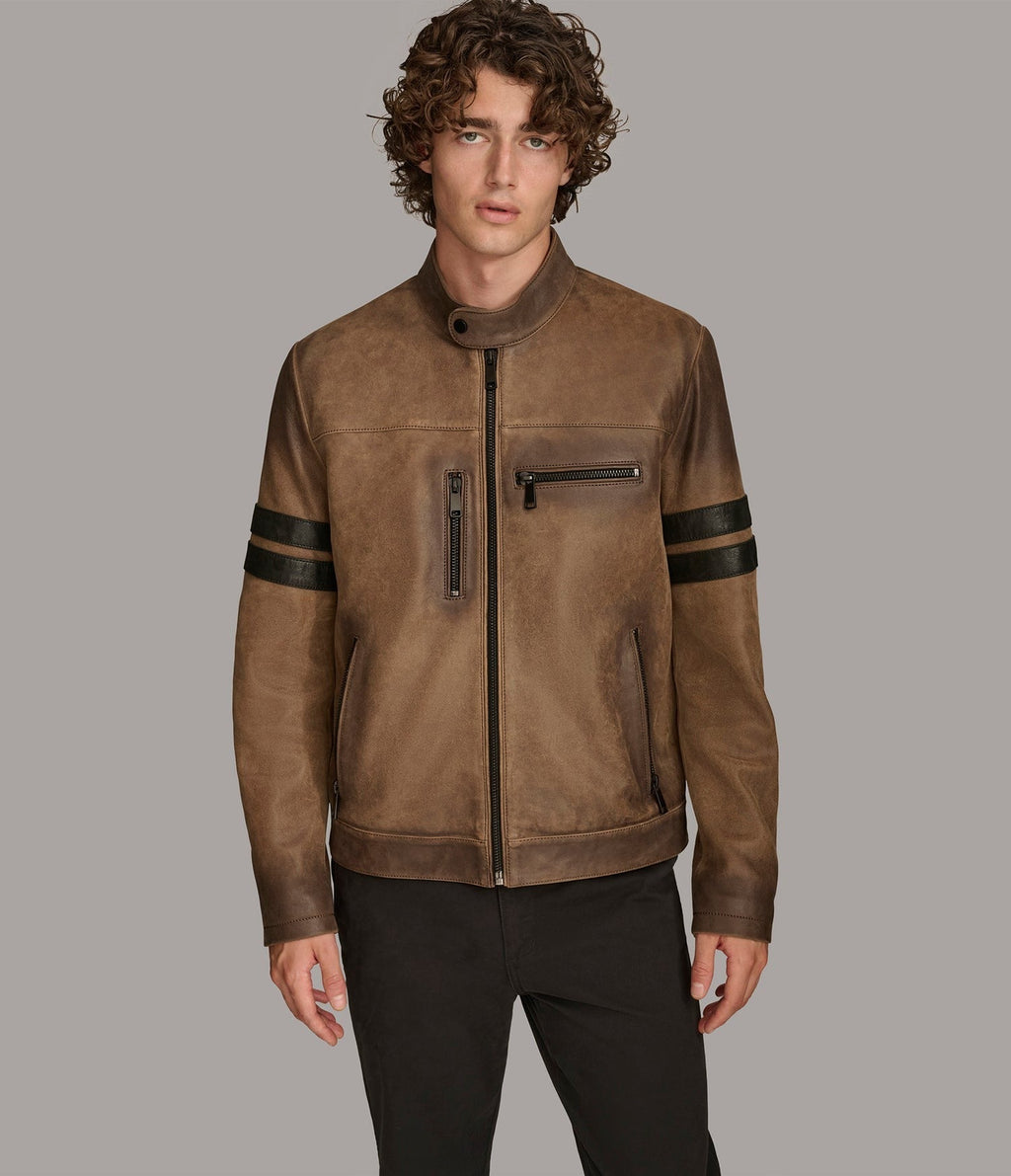 Man wearing a brown leather jacket with black accents on a gray background