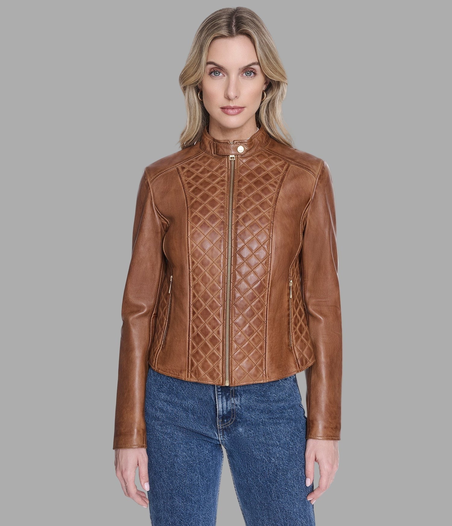 Woman wearing a brown leather jacket with a geometric pattern on a gray background