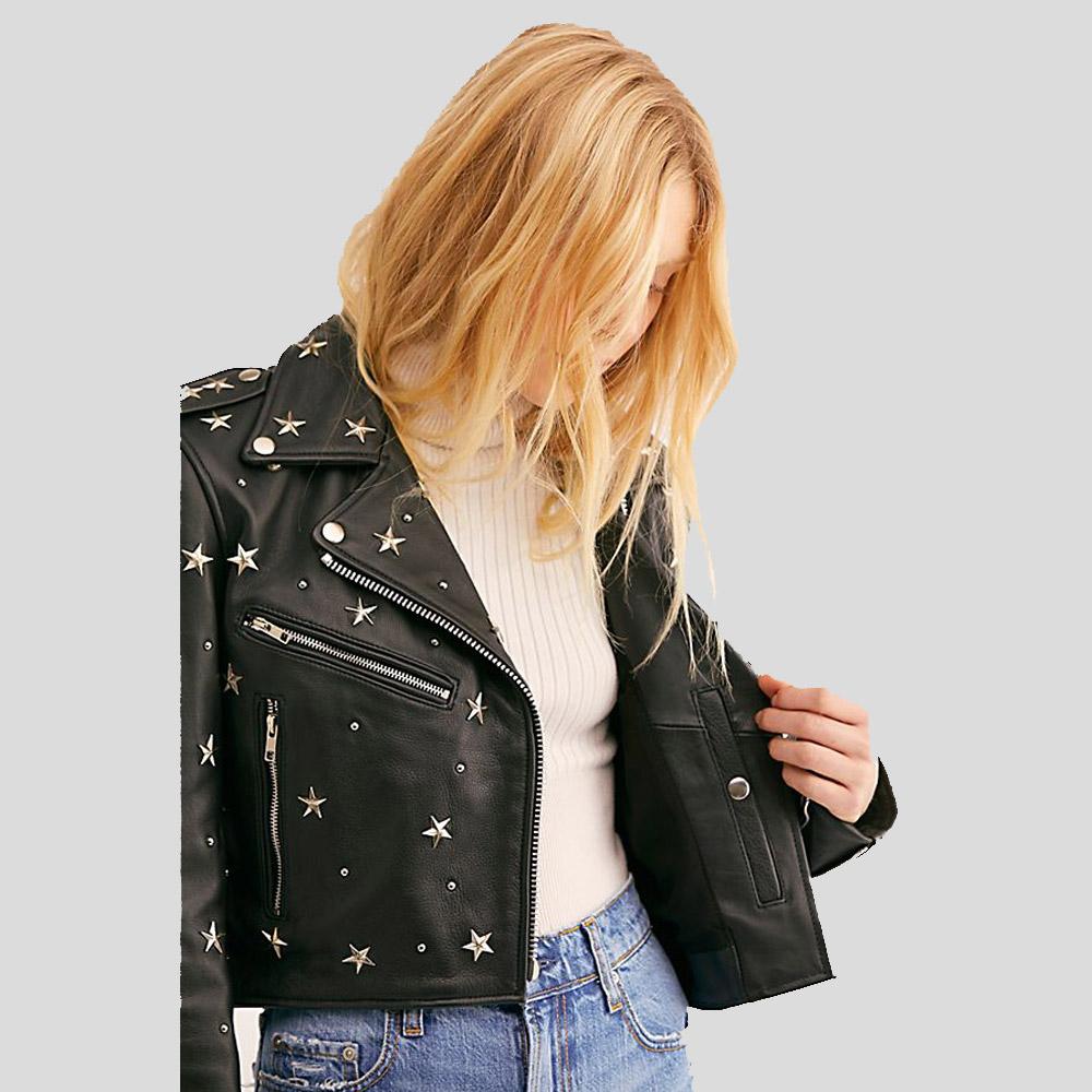 Person wearing a black leather jacket with star patterns on a gray background