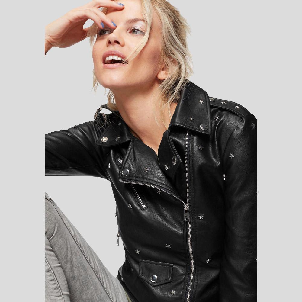 Woman wearing a black leather jacket with star embellishments on a light gray background