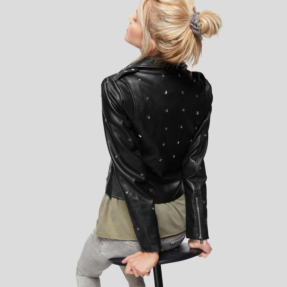 Person wearing a black leather jacket with star embellishments on a plain background