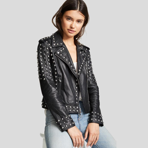 Woman wearing a black studded leather jacket on a gray background