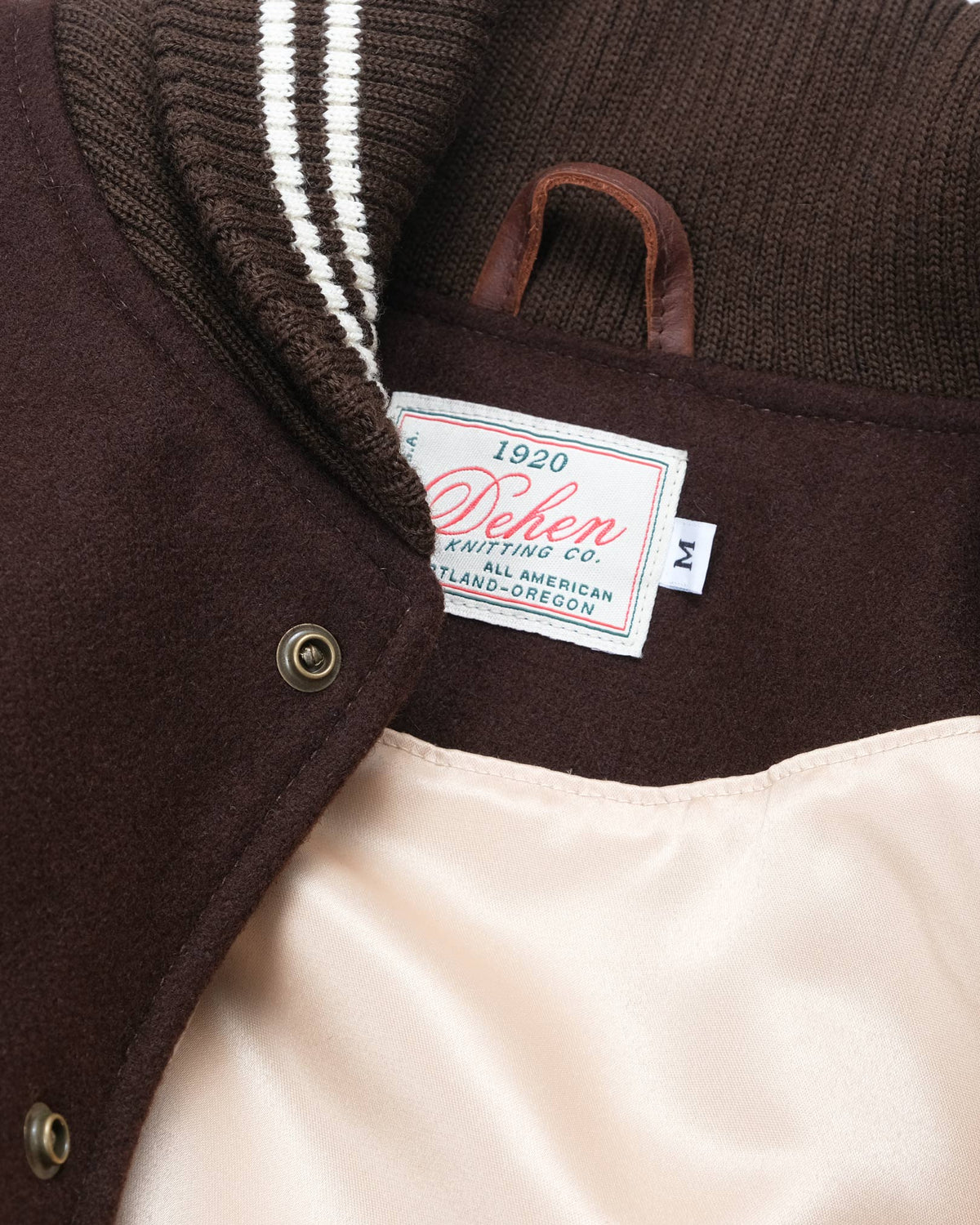 Close-up of a label on a brown jacket with a visible brand name.