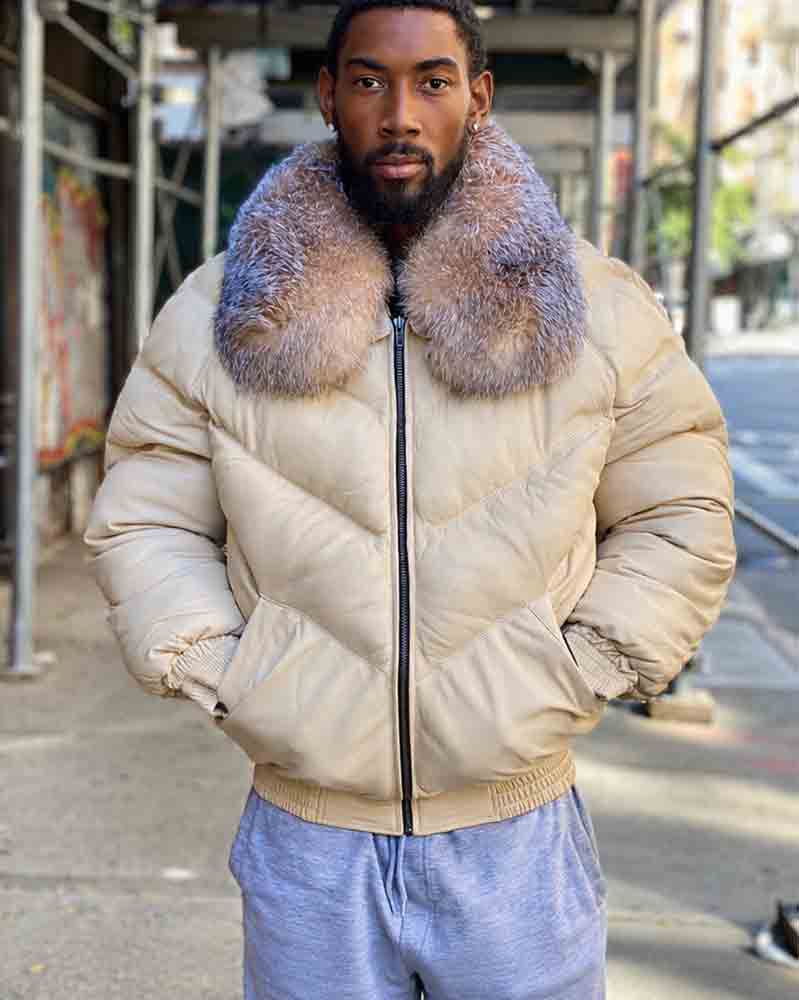 A man wearing an off-white goose country jacket with a large, crystal fox-fur collar, paired with light blue sweatpants, standing on an outdoor city sidewalk.