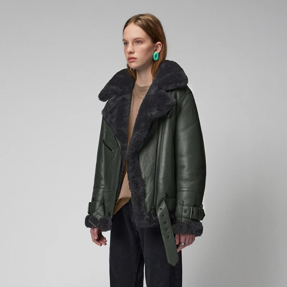 Person wearing a green leather jacket with fur trim on a gray background