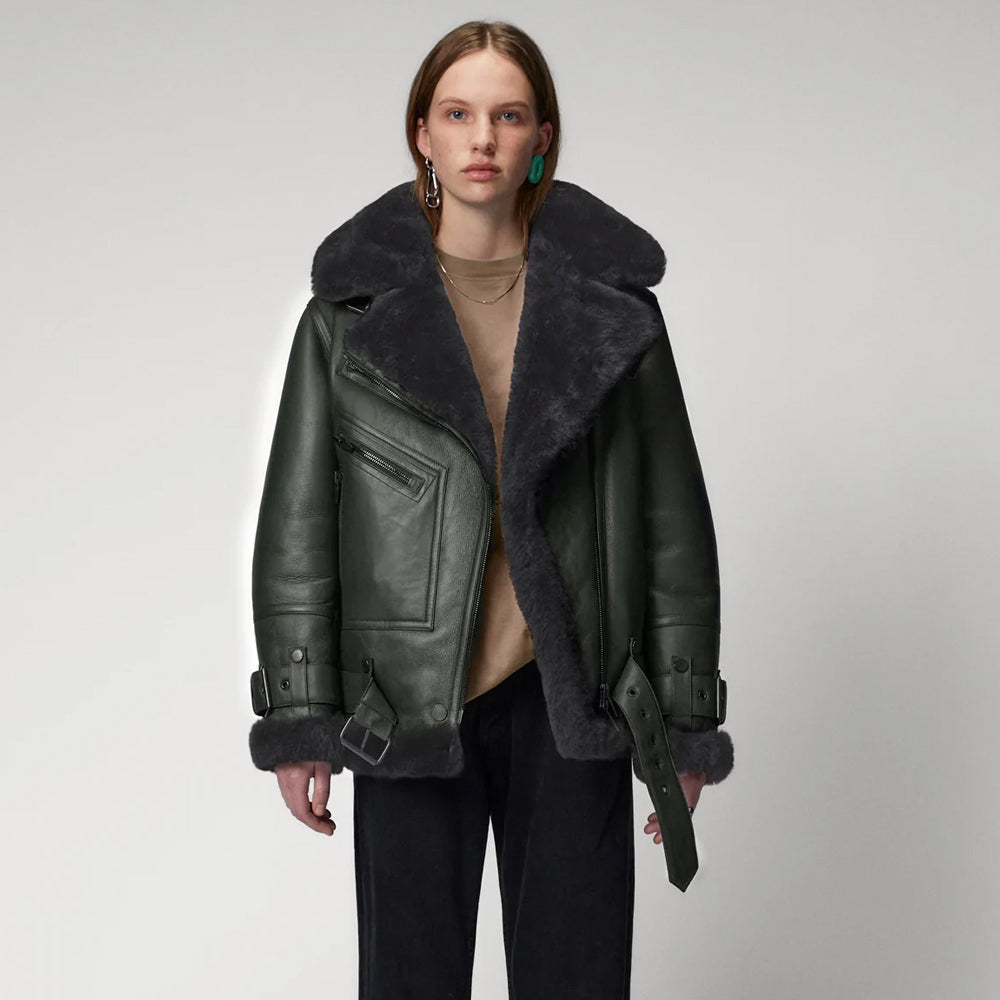 Person wearing a dark leather jacket with fur trim on a plain background