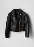 Black leather jacket with gold zippers on a light gray background