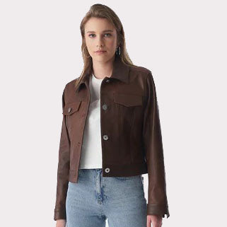 A woman modeling a dark brown cropped jacket with flap chest pockets, worn over a white top and light blue jeans, against a light gray studio background.
