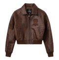 A brown textured leather jacket with crocodile-embossed panels and a tonal embroidered patch on the chest, shown against a plain white background.