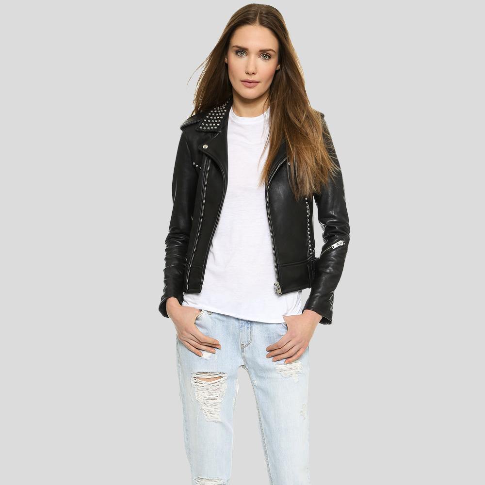 Woman wearing a black leather jacket with studs, white shirt, and light blue jeans on a gray background