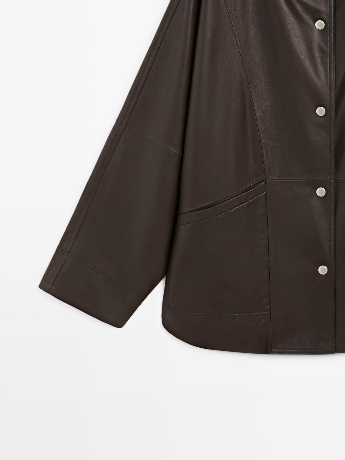 Close-up of a dark brown leather jacket with silver buttons, showing the texture and stitching details against a plain white background.