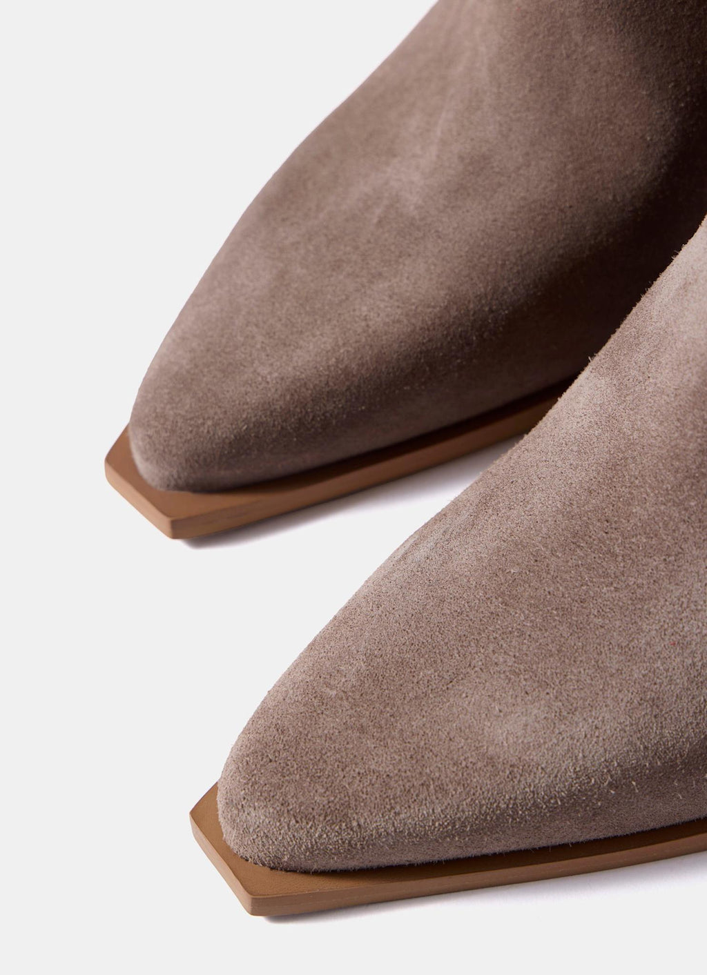 Close-up of a pair of pointed-toe ankle boots in taupe suede with a light brown block heel, shown against a clean white background.